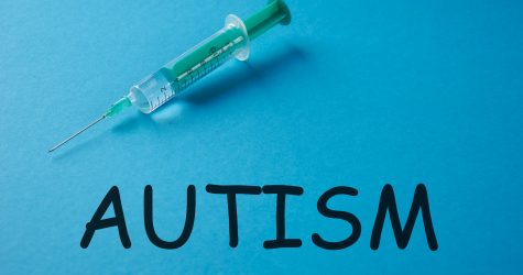 Word AUTISM and Syringe, medical injection on blue background